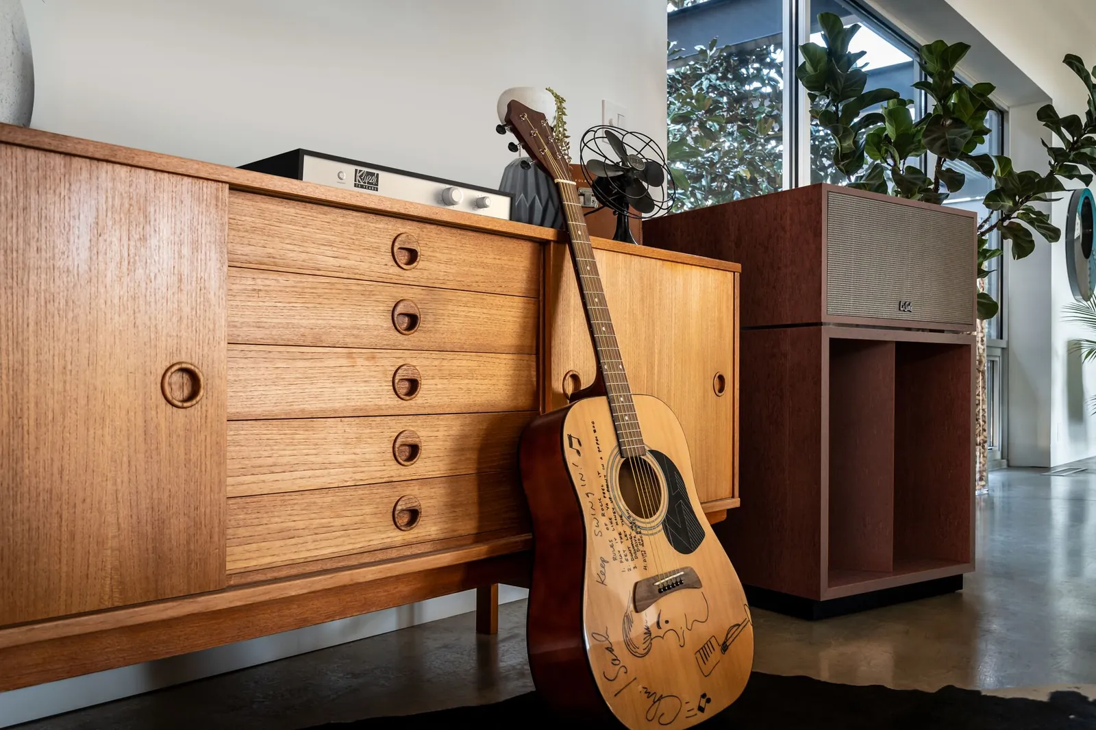 Enceinte Klipsch La Scala à côté d'un buffet en bois et d'une guitare