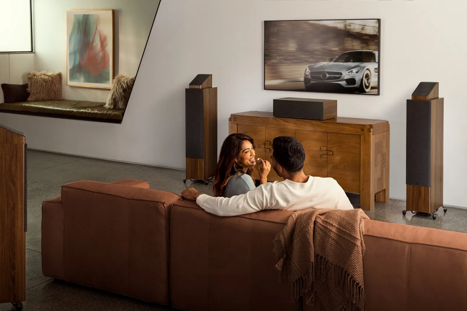 Enceintes colonnes Polk Reserve dans un salon, un couple devant la TV