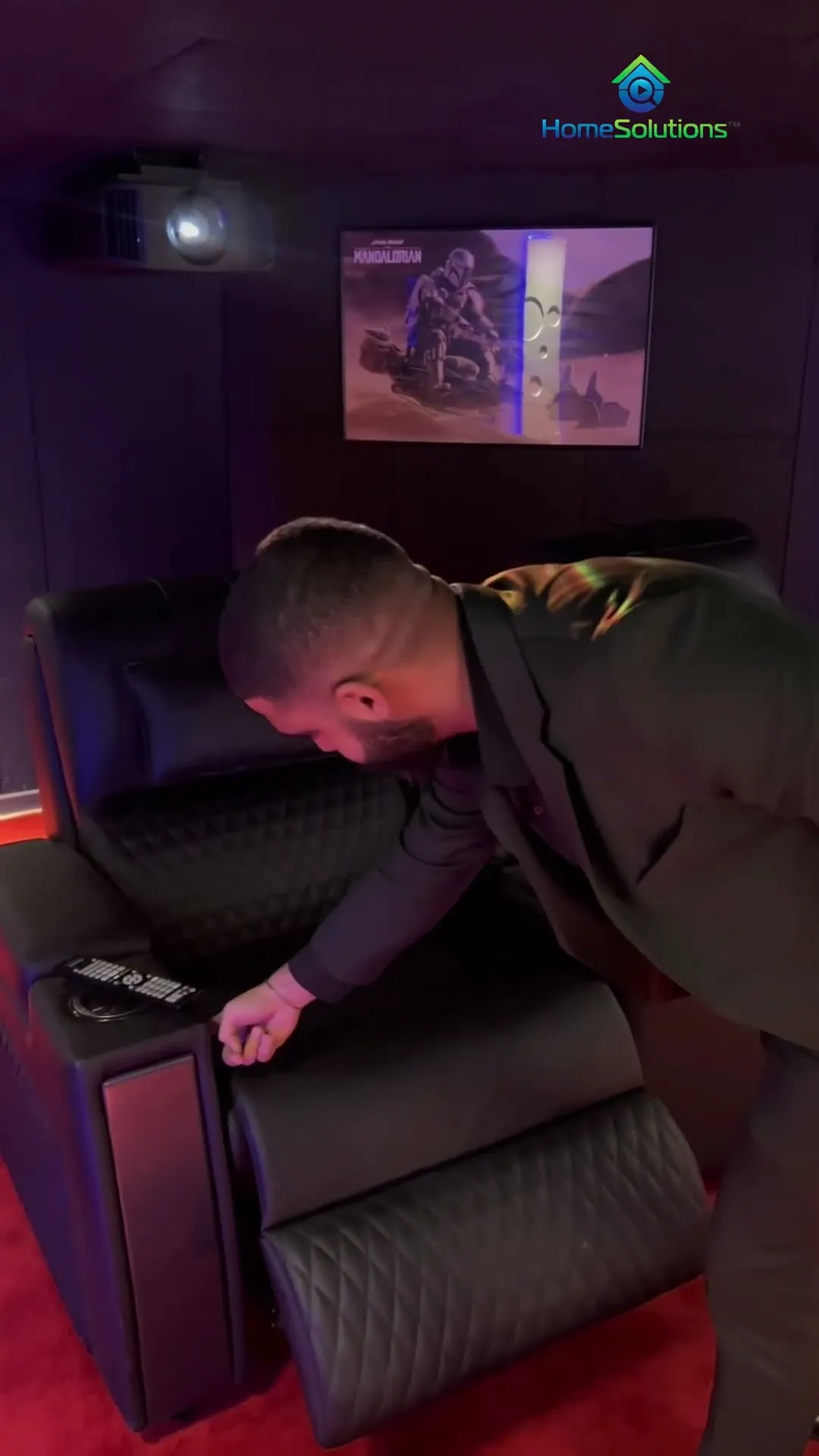 Intervention d'un technicien HomeSolutions sur un fauteuil motorisé, dans une salle livrée.